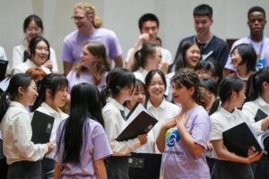 Des jeunes Chinois et Américains discutent pendant une pause lors d'une répétition d'un spectacle musical dans une école de Nanjing, dans la province chinoise du Jiangsu (est), le 17 juillet 2026. (Xinhua/Li Bo)